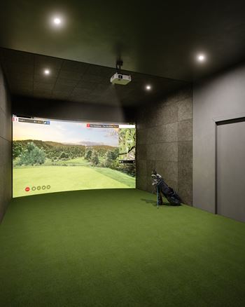A golf simulator room with a screen showing a golf course.
